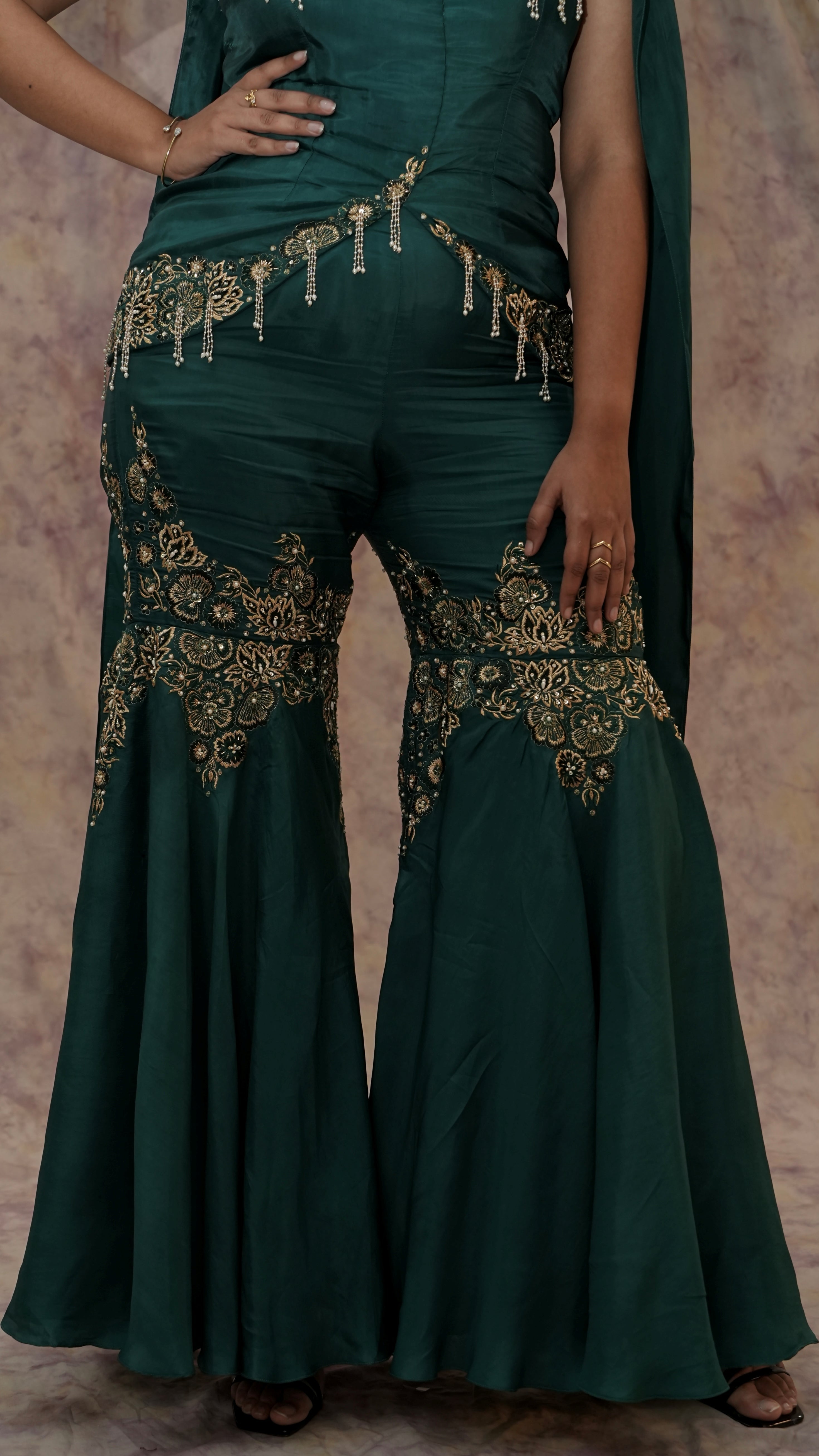 Green outfit with gold embroidery on a plain background