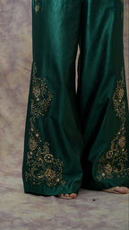 Green embroidered pants on a textured surface