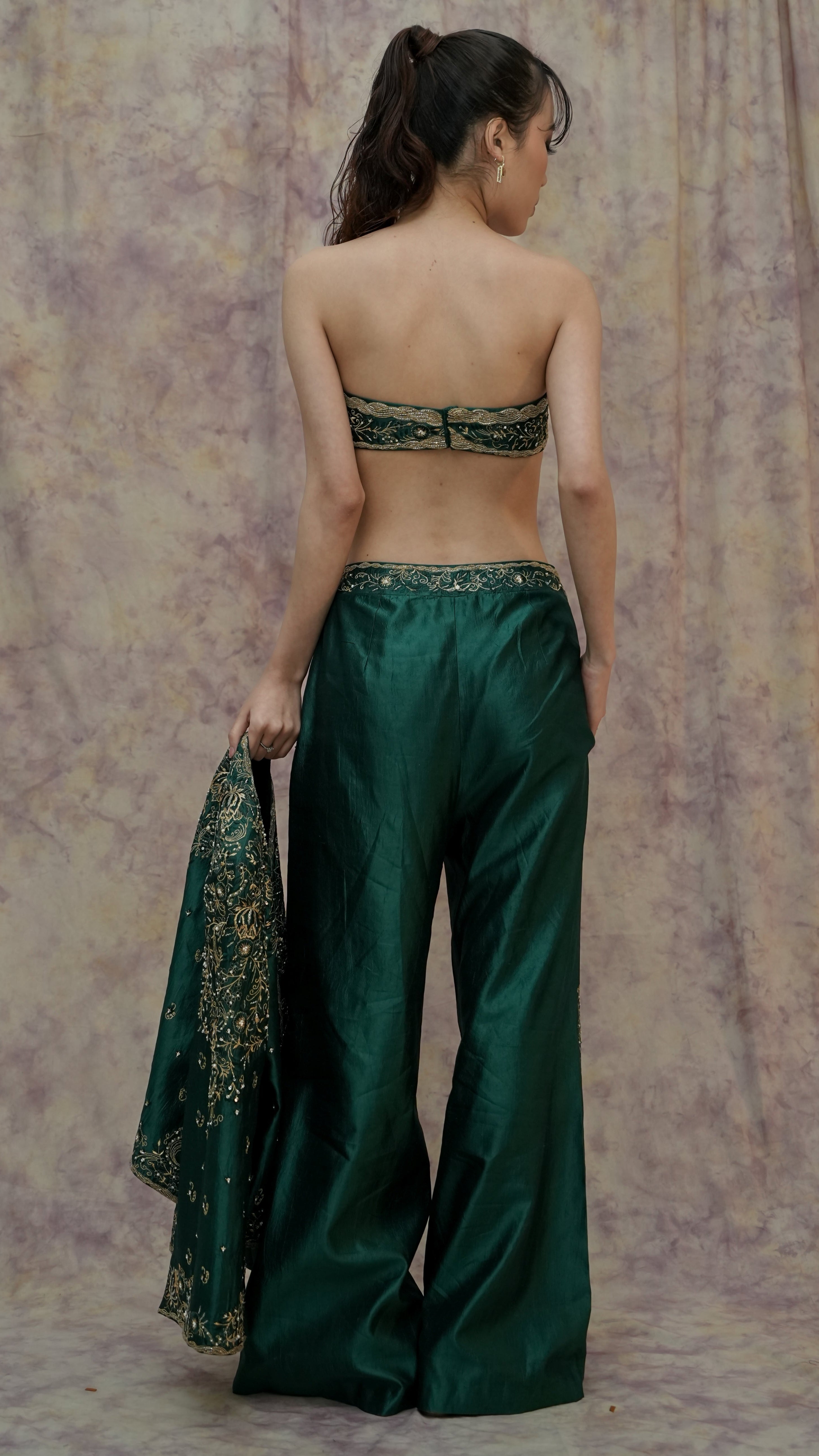 Woman wearing a green traditional outfit with a textured background