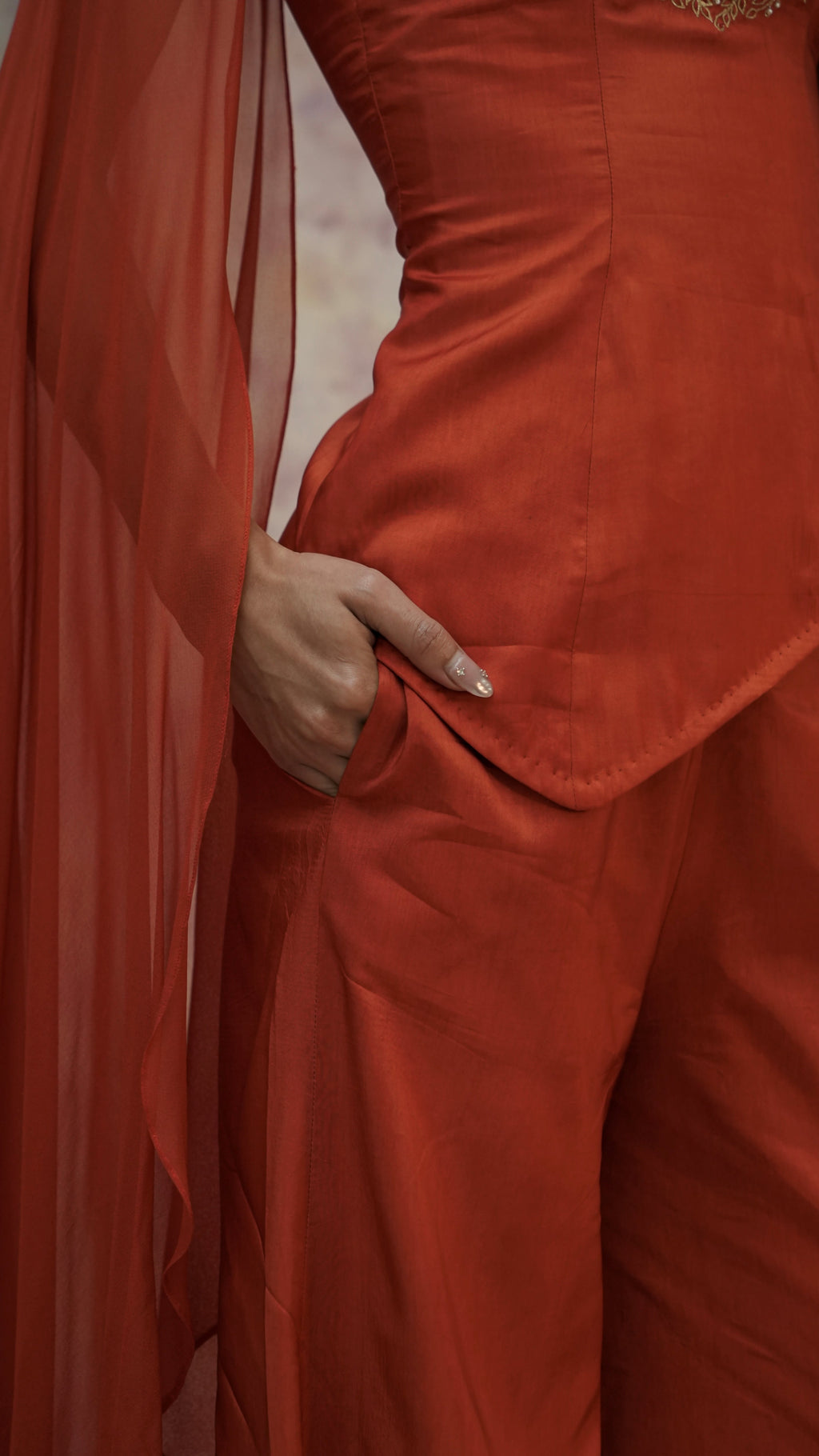 Person wearing a red outfit with a flowing fabric in the background