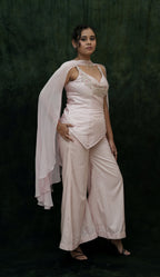 Woman wearing a light pink outfit with a dark background