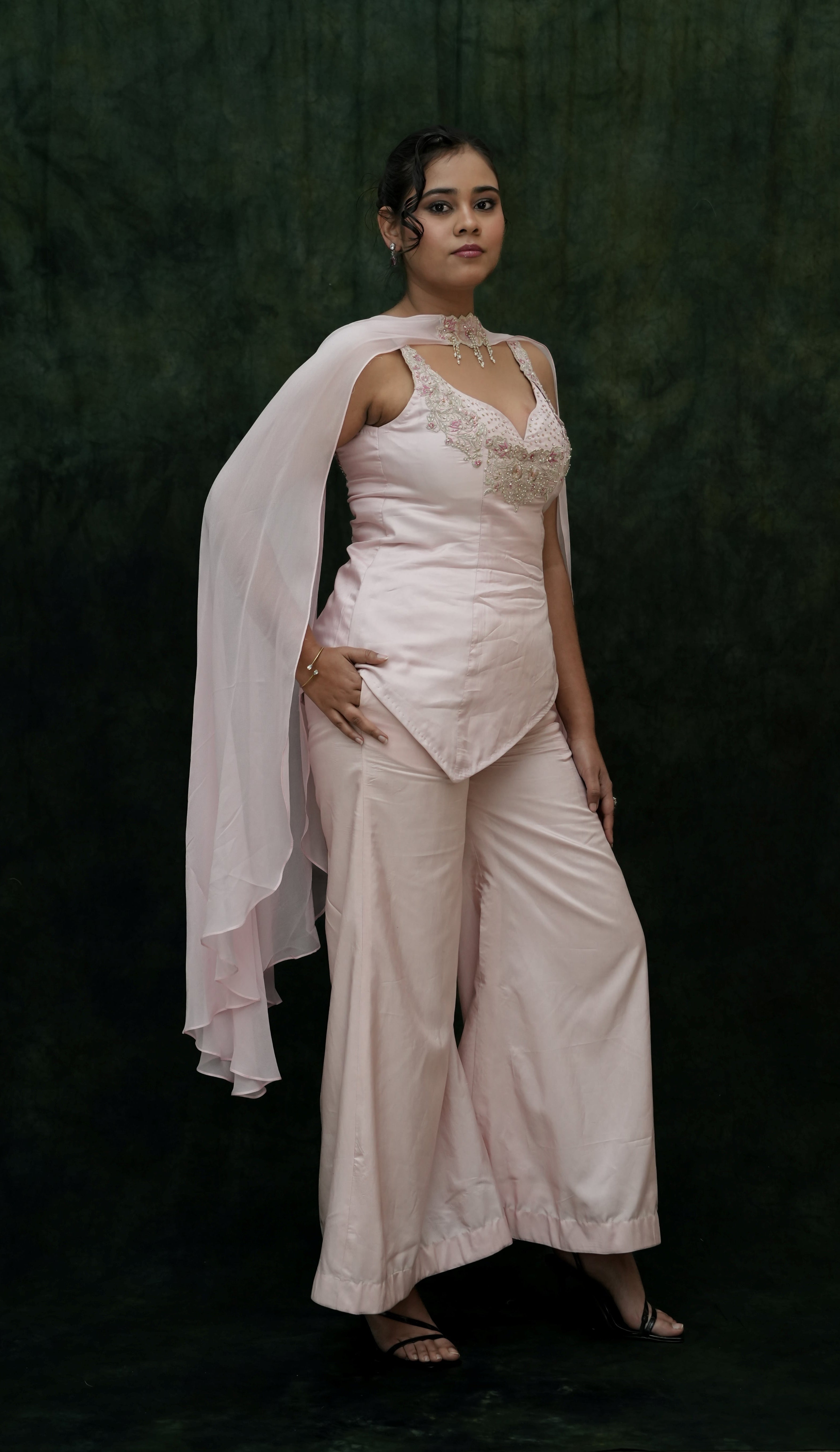 Woman wearing a light pink outfit with a dark background