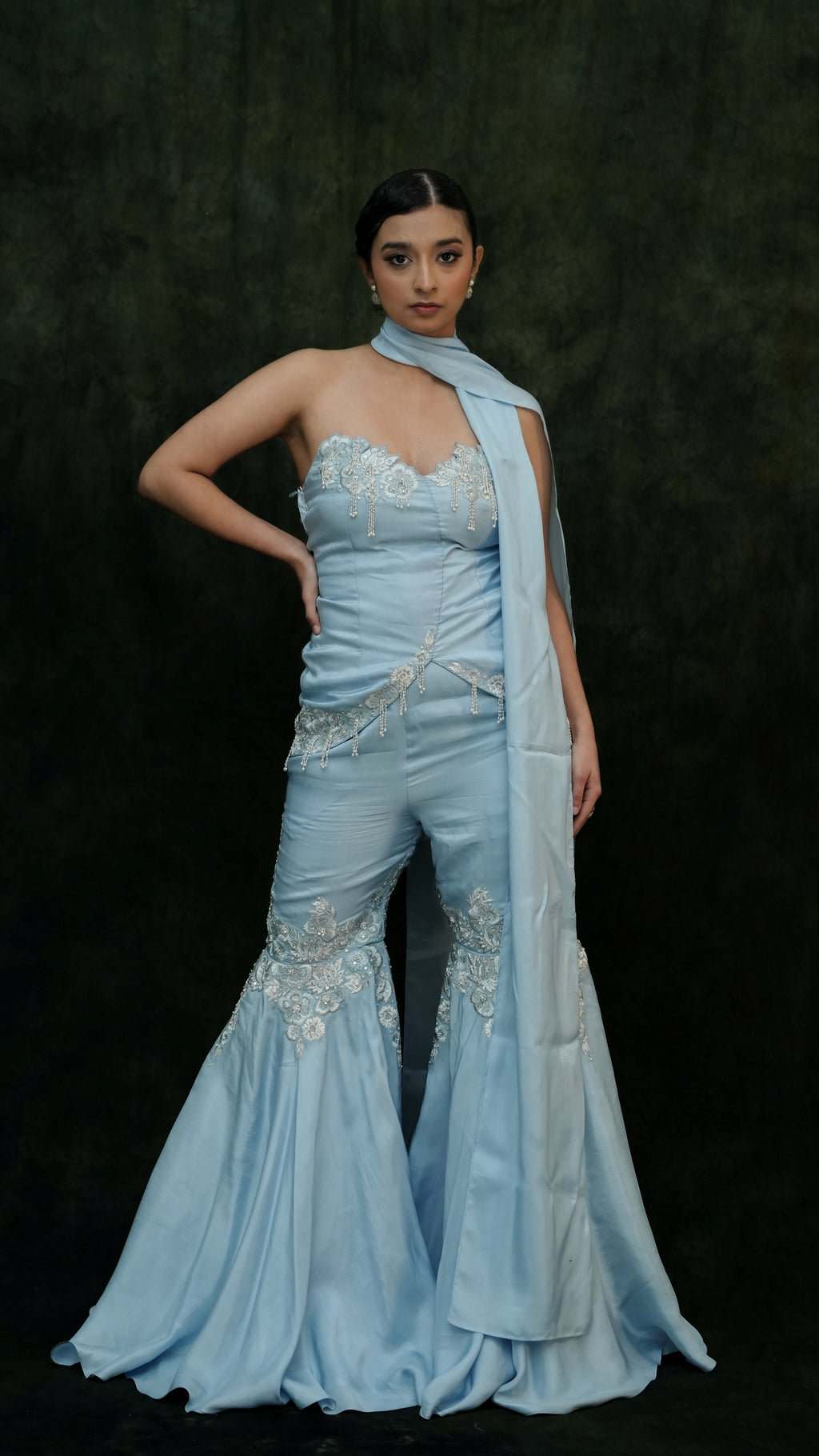 Woman wearing a light blue evening gown with a dark background