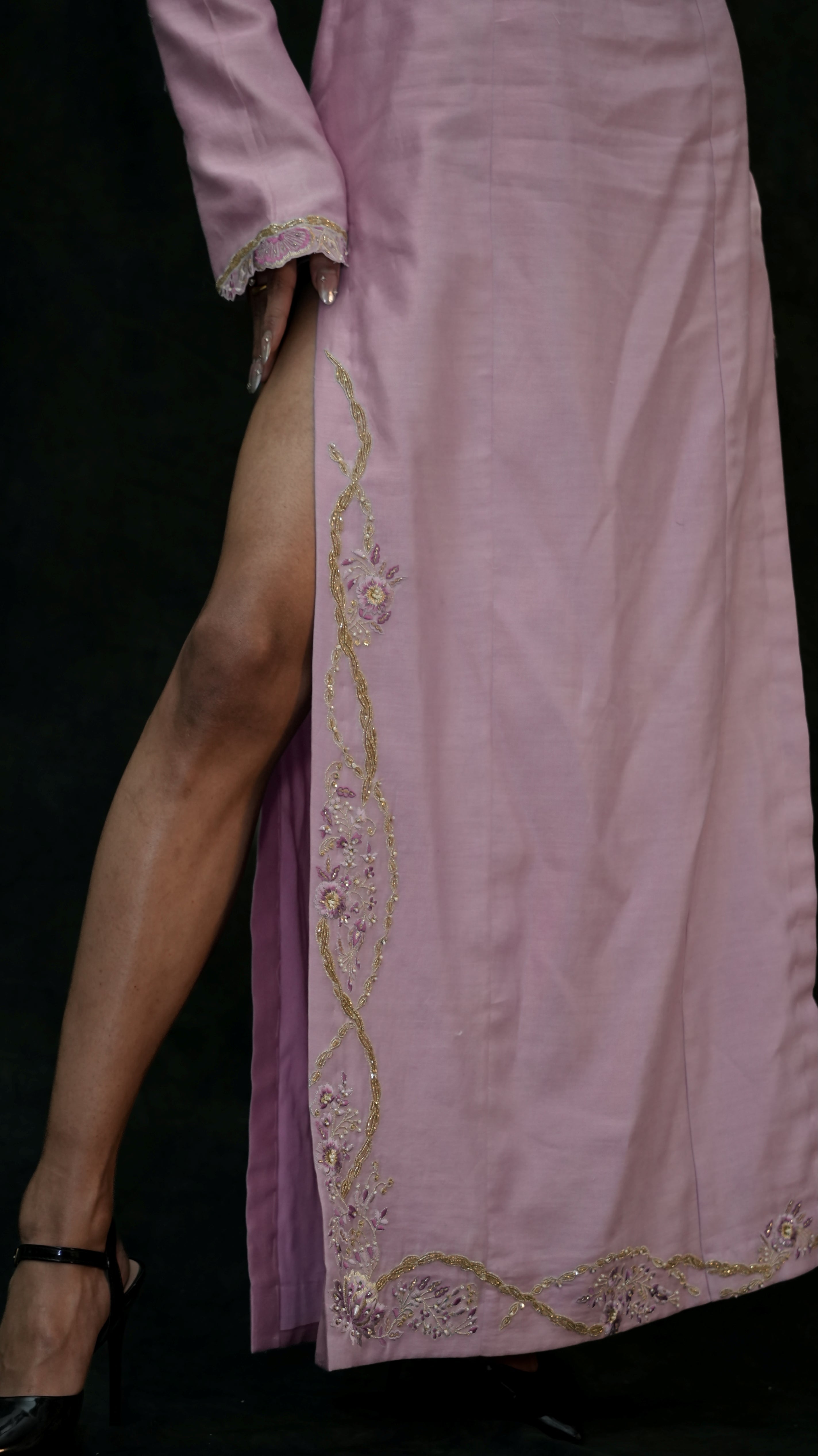 Pink dress with gold embroidery on a black background