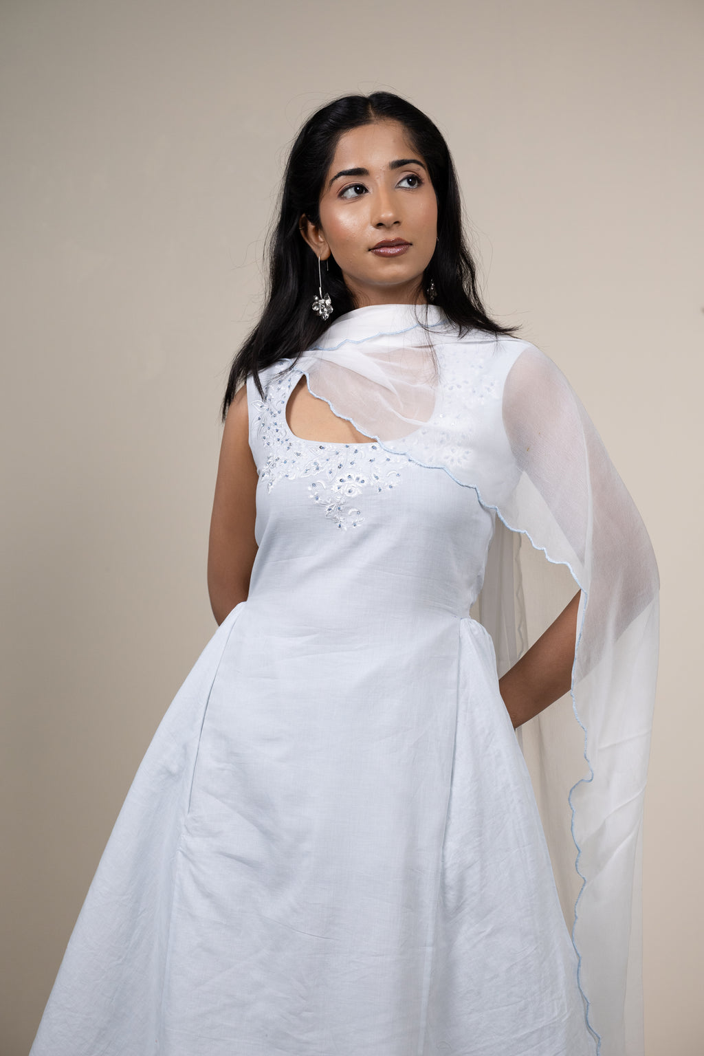 Woman wearing a white saree with a plain background