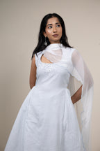 Woman wearing a white saree with a plain background