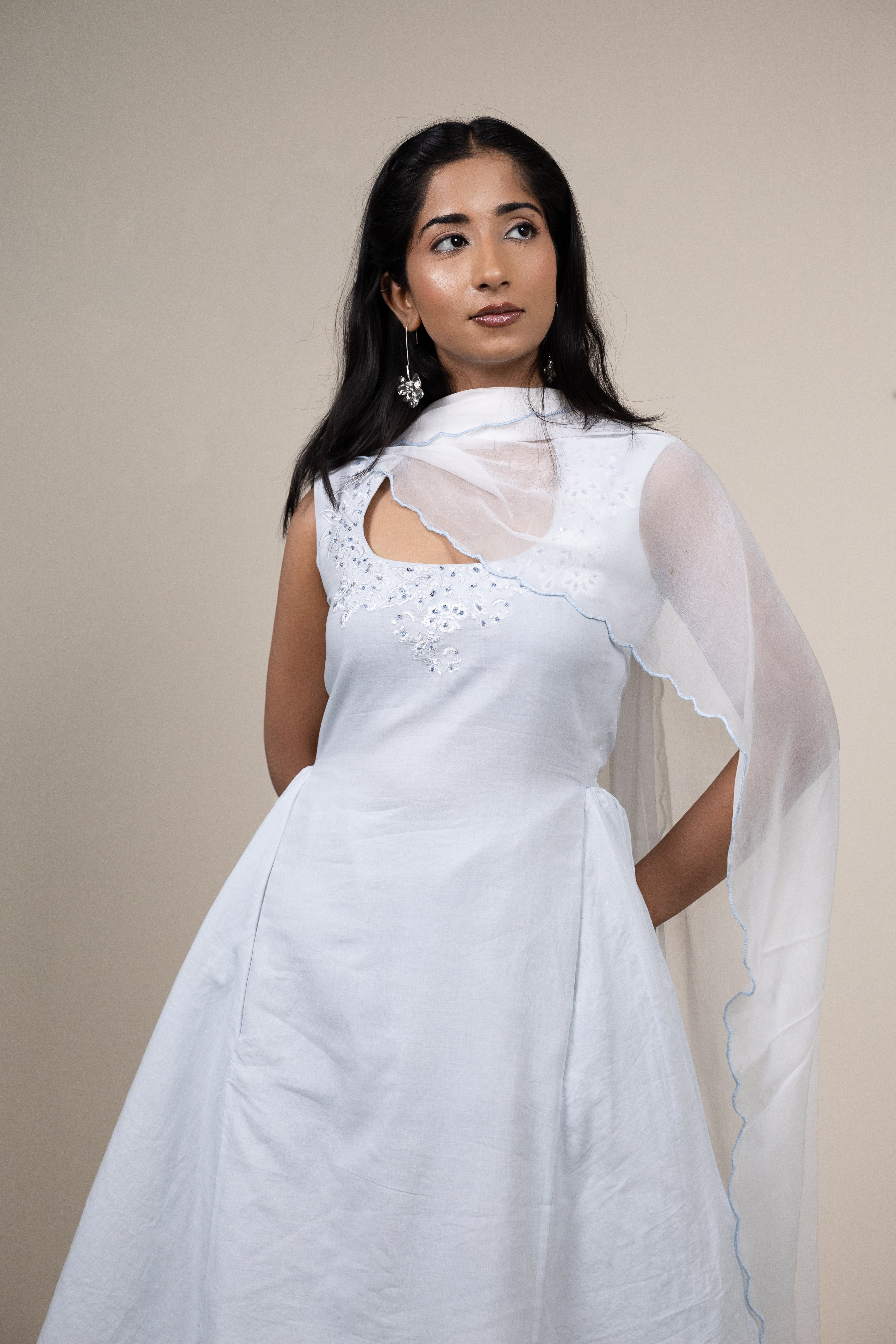 Woman wearing a white saree with a plain background